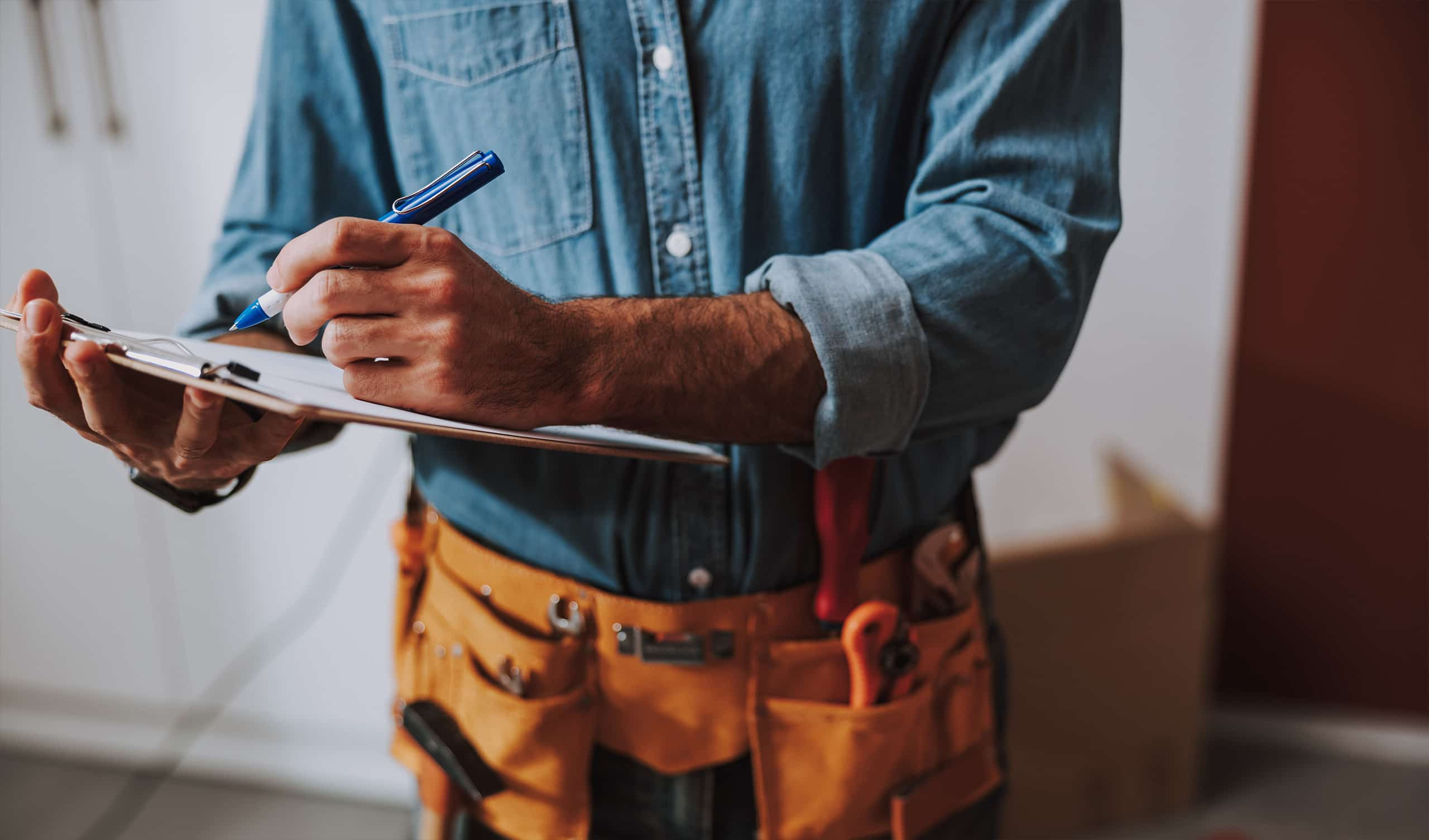 A technician making notes on a clipboard