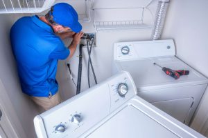 A plumber connecting water lines to a washing machine