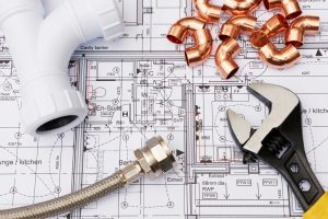 Various plumbing materials sitting on top of blueprints